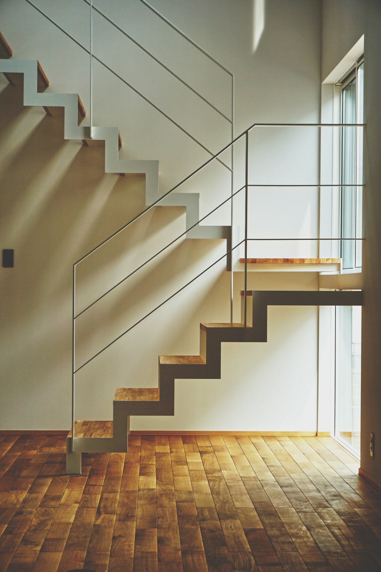 Un escalier aux marches de chêne, posé contre un mur clair
