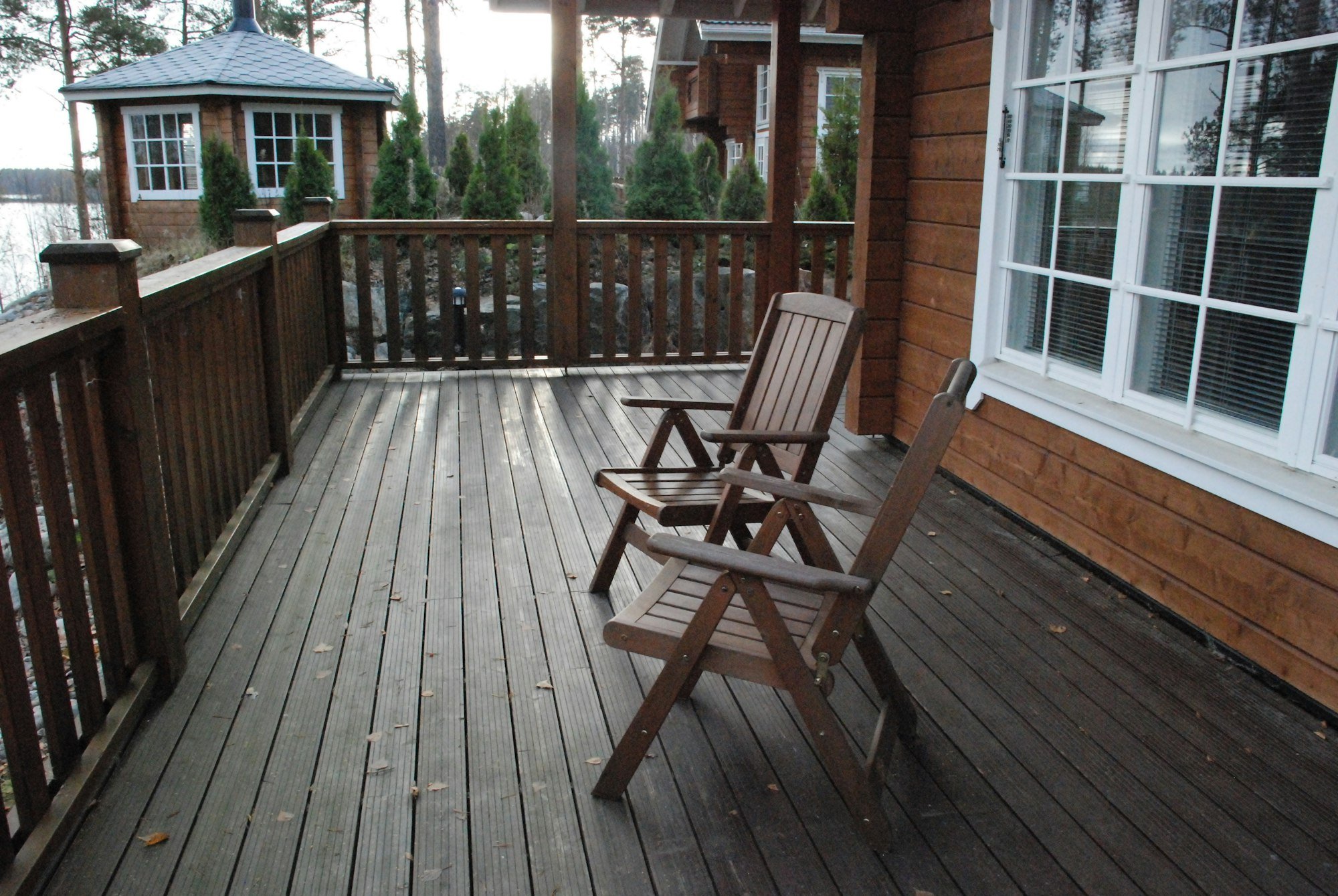 Une terrasse en bois et son garde-corps, au bord d’un lac
