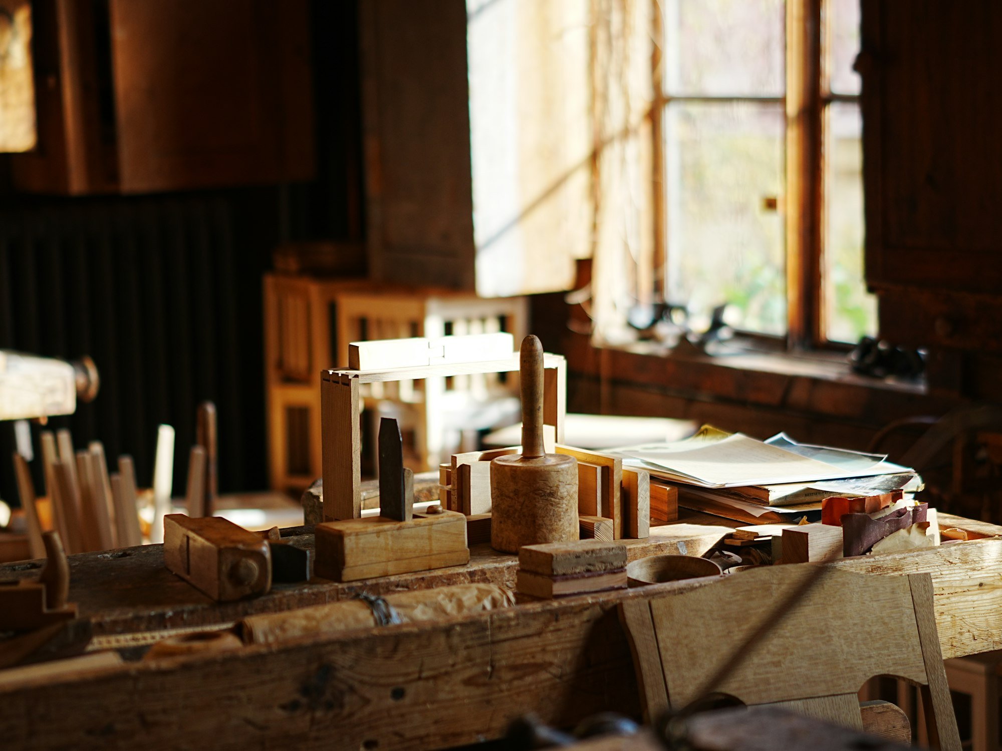 L’atelier : établis en bois, outils à main et lumière des grandes fenêtres